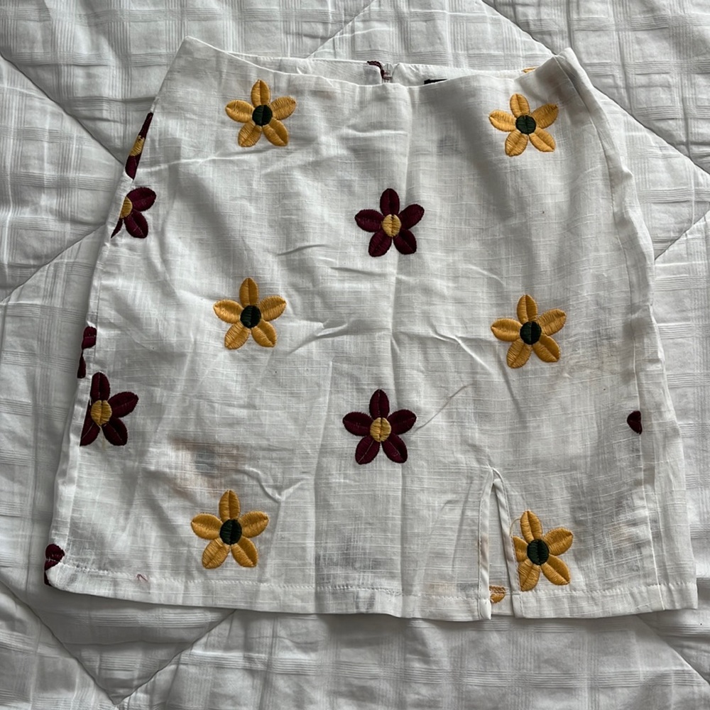 White with embroidered flower details. Size XS